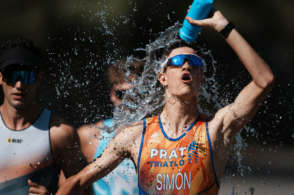 A triathlete is spraying water on a competitor.