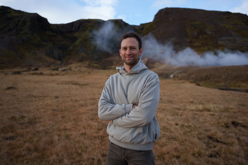 A man standing in front of a field with steam coming out of it.