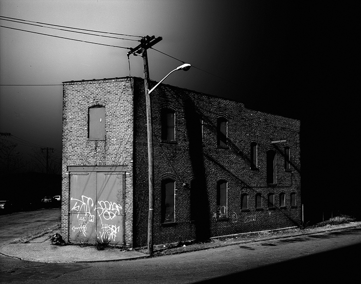 A black and white photo of a building with graffiti on it.