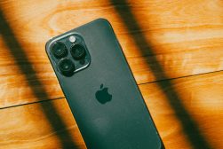 a close up of a iphone 14 on a wooden surface.