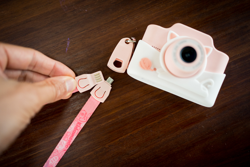 a person holding a pink camera next to a pink camera.