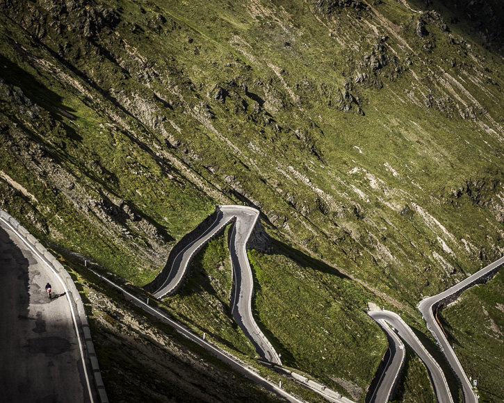 An aerial view of a winding road in the swiss alps.