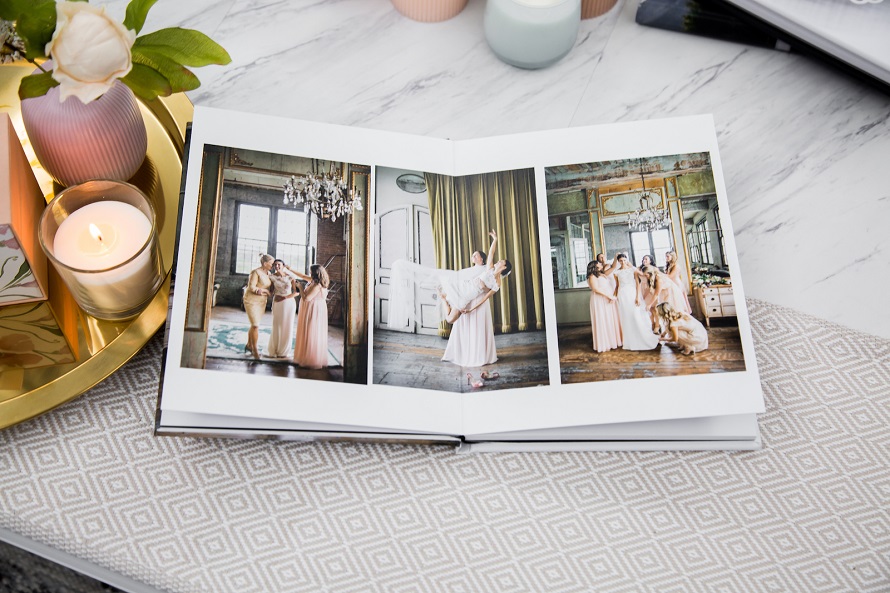 A photo book with photos of bridesmaids on a table.