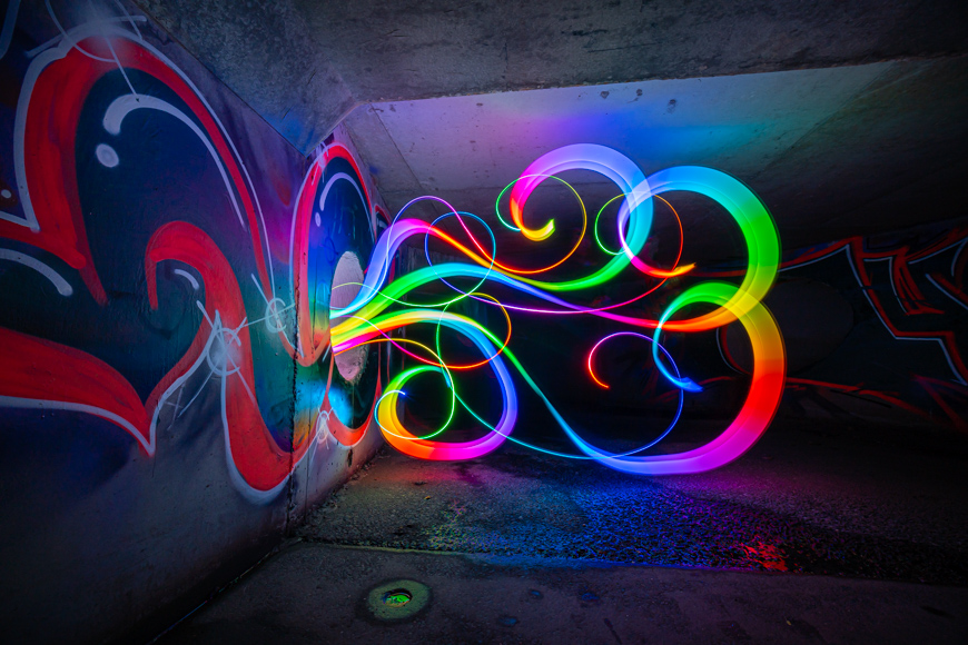 A colorful light painting in a dark tunnel.