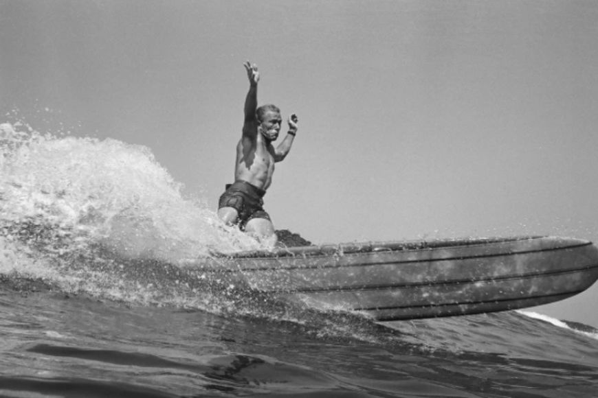 A man riding a surfboard on a wave.
