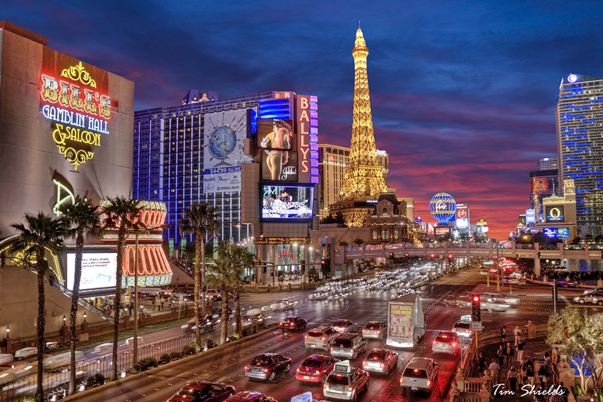 Las vegas at dusk with the eiffel tower in the background.